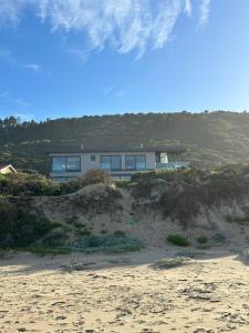 a house sitting on top of a sandy beach at Marien Beach House in Glentana