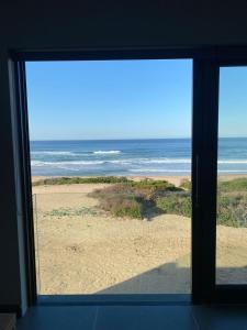 a view of the beach from a window at Marien Beach House in Glentana