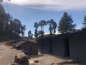 Una casa está siendo construida al lado de una calle en Shivoham valley view camps, en Mussoorie