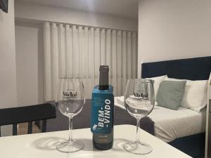 a bottle of wine sitting on a table with two wine glasses at Apartamentos do Corgo in Vila Real