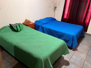 two beds with blue and green sheets in a room at Casa quinta El Descanso in General Rodríguez