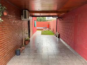 an empty alley with a red brick wall at Casa quinta El Descanso in General Rodríguez