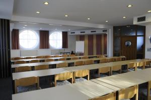a lecture room with rows of tables and chairs at Parkhotel Cham in Cham