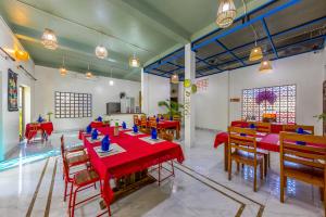 a dining room with red tables and chairs at Tropical retreat Homestay in Cat Ba