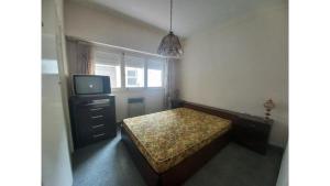 a small bedroom with a bed and a tv at Depto San Francisco in Mar del Plata