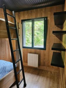 a room with a bunk bed and a window at Chalet en forêt avec etang. in Saint-Étienne-lès-Remiremont