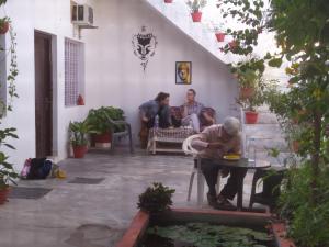 um grupo de pessoas sentadas em torno de uma mesa em um pátio em The Highvill Home Stay em Khajurāho