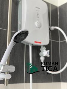 a white faucet in a bathroom with a mirror at Rumah Tiga Tingkat in Kuantan