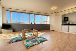 a living room with a table and some windows at Mitomi Home 4F in Tokyo