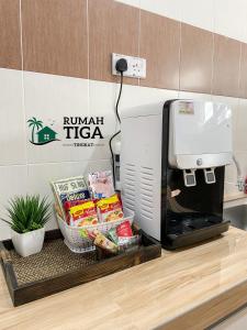a kitchen counter with a coffee maker and food at Rumah Tiga Tingkat in Kuantan