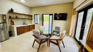 a dining room with a glass table and chairs at Estudio a 5 minutos de Sayulita -Parota 1 in San Ignacio