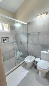 uma casa de banho com um chuveiro, um WC e um lavatório. em Vista Alegre Natural Resort - Bungalows em Independencia