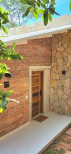 a brick building with a door and a stone wall at Vista Alegre Natural Resort - Bungalows in Independencia