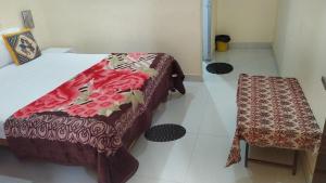 een kamer met 2 bedden en een tafel en kruk bij The Highvill Home Stay in Khajurāho