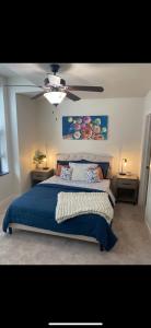 a bedroom with a blue bed with a ceiling fan at Sapphire desire in Indianapolis