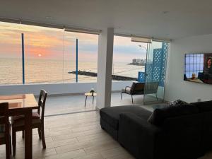 a living room with a couch and a view of the ocean at La mejor Vista al Point de la Playa San Bartolo in San Bartolo
