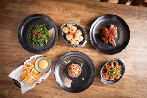 four plates of food on a wooden table at Lodge Yokochi in Nozawa Onsen