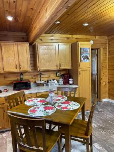 uma cozinha com uma mesa de madeira com placas em The Lazy Bear Cabin em Long Lake