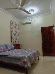 sypialnia z łóżkiem i wentylatorem sufitowym w obiekcie D'HYA HOMESTAY w mieście Alor Setar