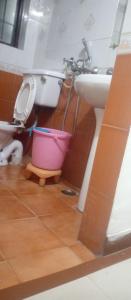 a bathroom with a toilet and a sink and a bucket at Hotel king palace in Chandīgarh