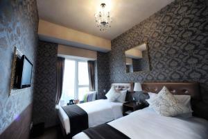 um quarto de hotel com duas camas e um lustre em Best Western Hotel Causeway Bay em Hong Kong