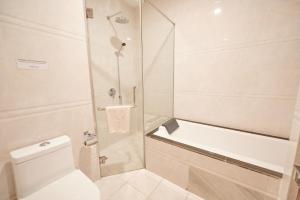a white bathroom with a shower and a toilet at Lbn Asian Hotel in Kampong Cham