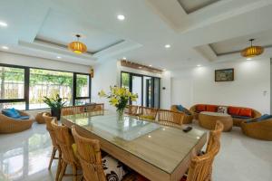a living room with a large wooden table and chairs at Amaia Homestay - a beach home away from home in Phú Quốc