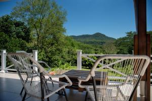 2 Stühle und ein Tisch auf einer Veranda mit Aussicht in der Unterkunft Vista Alegre Natural Resort - Villas & Cabañas in Independencia