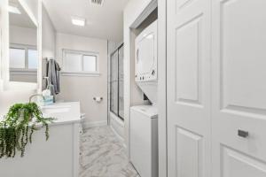 La salle de bains blanche est pourvue d'un lavabo et d'un lave-linge. dans l'établissement Exceptional 3BR on Eastside, à Bartlesville