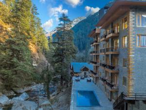 un complexe avec une piscine dans les montagnes dans l'établissement Bradhi - Echor Riverside Resort Jibhi, à Jibhi