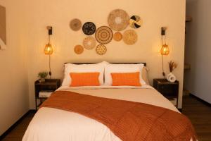 a bedroom with a bed with orange pillows and plates on the wall at Avani in Contadora