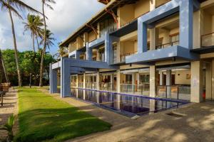 an exterior view of a building with a swimming pool at Cocobay Unawatuna in Unawatuna