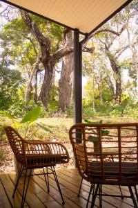two wicker chairs sitting on a screened porch at Avani in Contadora