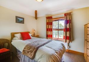 Schlafzimmer mit einem Bett und einem Fenster in der Unterkunft The Lodge in Llanwnda