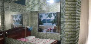 ein Schlafzimmer mit einem Bett und zwei Bildern an der Wand in der Unterkunft QUICKSHAPE FITNESS GYM/QUICKSHIELD HOMESTAY in Naga