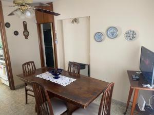 Un comedor con mesa y sillas de madera. en Casa Rosa, en Alta Gracia