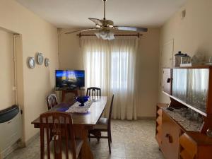 a dining room with a table with chairs and a television at Casa Rosa in Alta Gracia