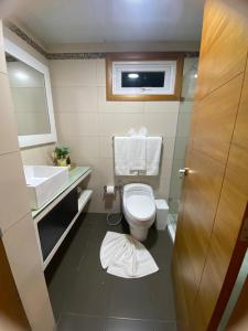 a bathroom with a toilet and a sink at Majestuoso Apto. en el Complejo Marbella, Juan Dolio in Juan Pedro