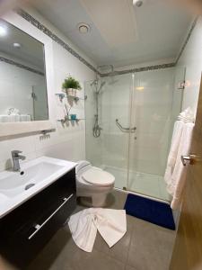 a bathroom with a shower and a toilet and a sink at Majestuoso Apto. en el Complejo Marbella, Juan Dolio in Juan Pedro