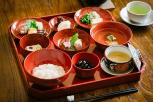 a tray filled with dishes of food on a table at Maana Kamo in Kyoto