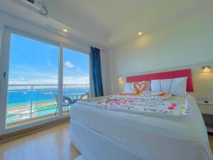 a bedroom with a large bed with a view of the ocean at iCom Marina Sea View in Maafushi