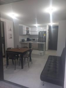 een woonkamer met een tafel en stoelen en een keuken bij Apartamento cómodo con todo lo que necesitas y con piscina in Ricaurte
