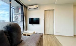ein Wohnzimmer mit einem Sofa und einem TV in der Unterkunft Laguna Skypark in Phuket