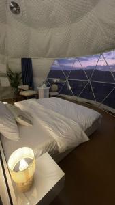 1 dormitorio con 1 cama grande y ventana grande en Black Sand Camp en Al Mintirib