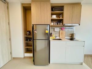 einen Kühlschrank aus Edelstahl in einer Küche mit weißen Schränken in der Unterkunft Laguna Skypark in Phuket
