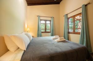 a bedroom with a large bed with two windows at Vista Alegre Natural Resort - Villas & Cabañas in Independencia