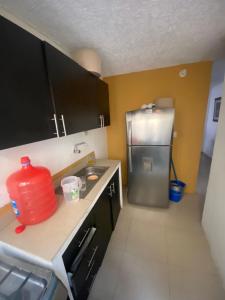 eine Küche mit einer Spüle und einem Kühlschrank in der Unterkunft Encantadora villa en una cdla privada in Candelaria