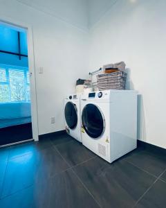 a white washing machine sitting in a room at Chatsworth Cottage in Upper Hutt