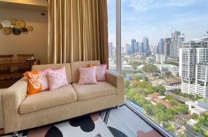 sala de estar con sofá y ventana grande en 2 Bedroom Luxury Apartment 3 min walk from BTS Ekkamai en Bangkok