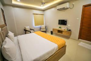 ein Hotelzimmer mit einem Bett und einem TV in der Unterkunft Hotel Jataka Inn , Bodh Gaya in Bodh Gaya